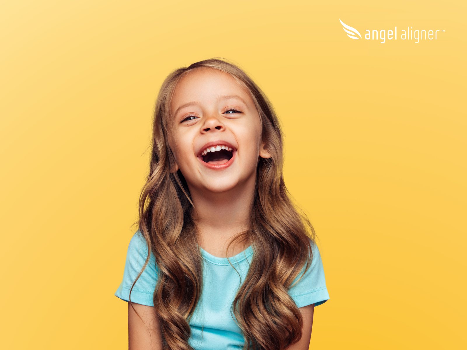 Lachendes Mädchen vor gelbem Hintergrund mit Angel-Aligner-Logo.